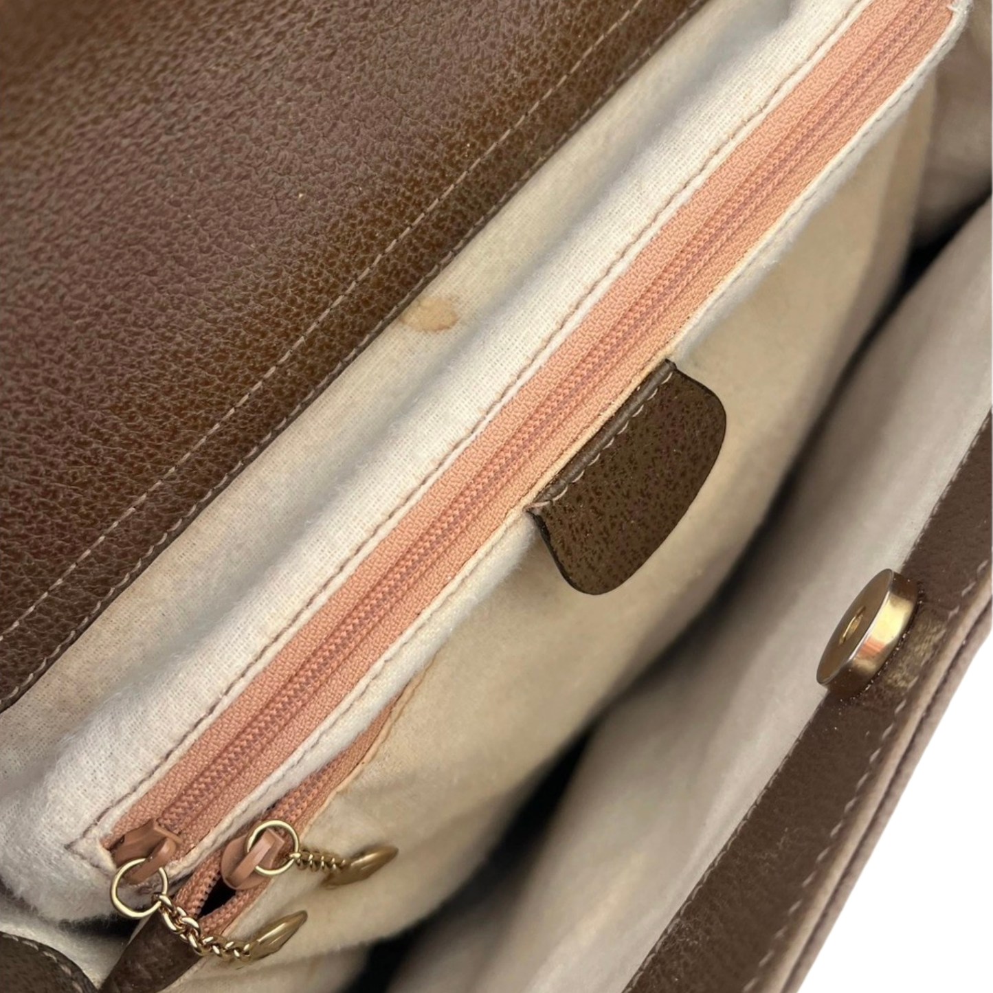 Close-up interior leather Guccibbag with a zipper and Logo