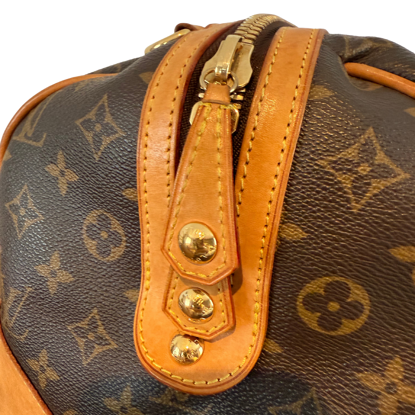 Close-up of a Louis Vuitton monogram handbag with gold hardware.