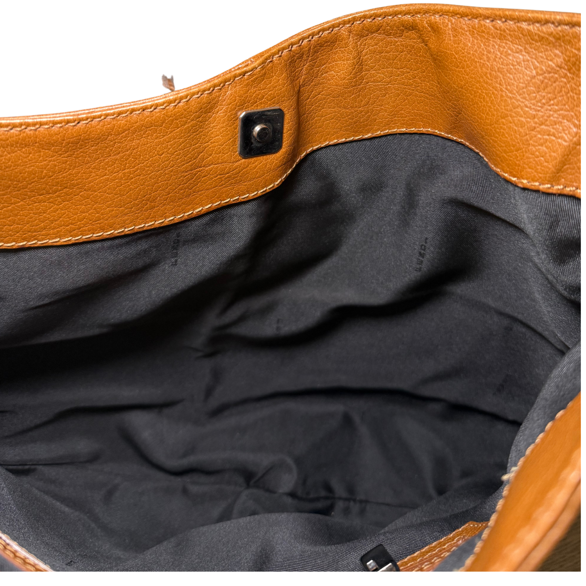 Close-up of a brown leather Fendi bag with a dark interior lining.