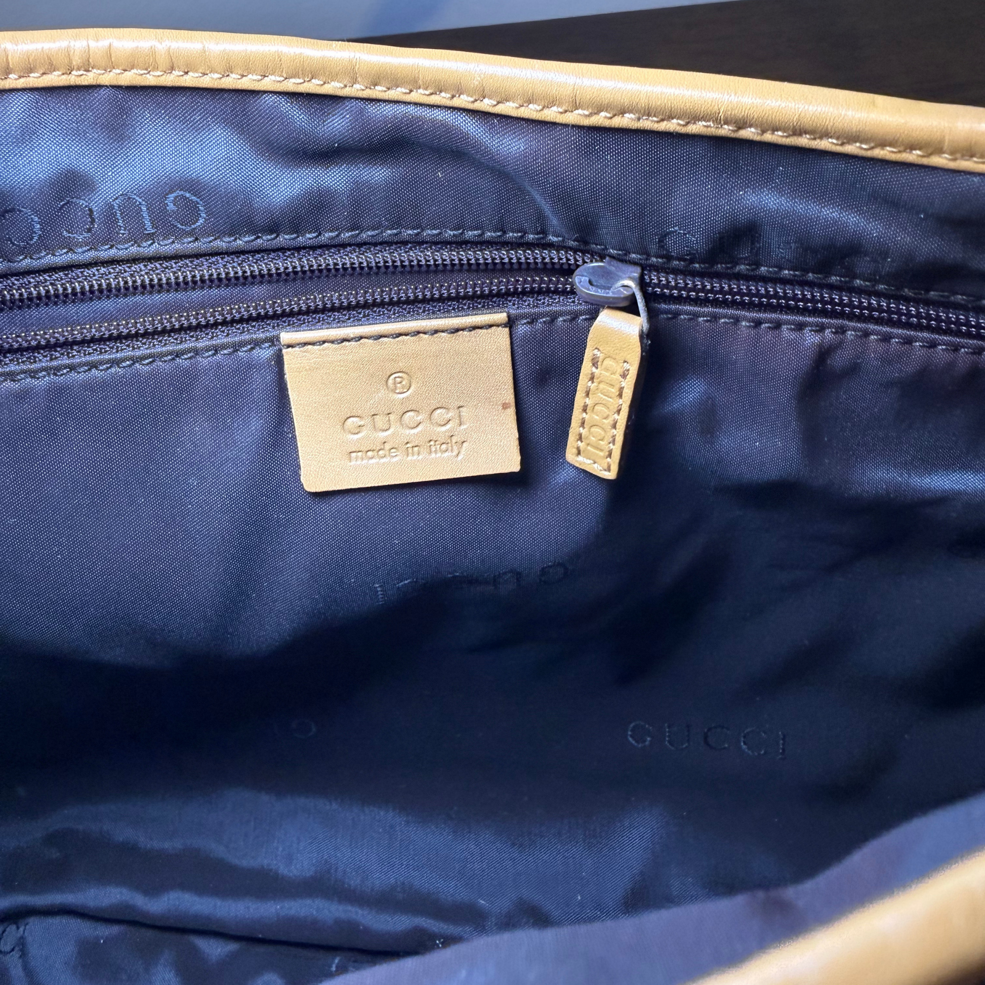 Interior Black in Gucci bag with gold tag and logo on a black surface