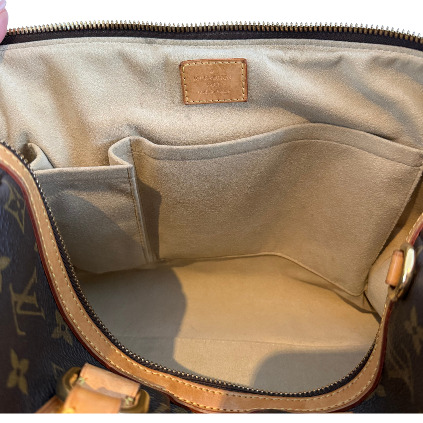 Open Louis Vuitton Stephen Boston handbag showing interior with visible brand logo.